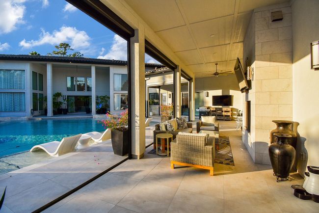 Luxury outdoor living with fireplace and stunning views of the pool - note the motorized shades to provide shade or privacy. | Image 43