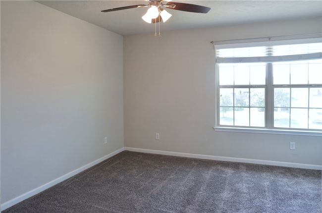 Empty room with ceiling fan, carpet flooring, and baseboards | Image 16