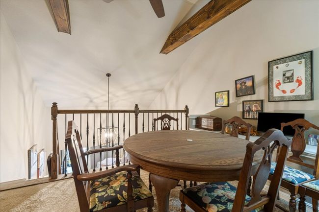 Carpeted dining room with ceiling fan and lofted ceiling with beams | Image 35