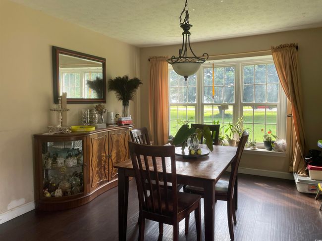 Dining space with dark wood finished floors, plenty of natural light, and a textured ceiling | Image 15