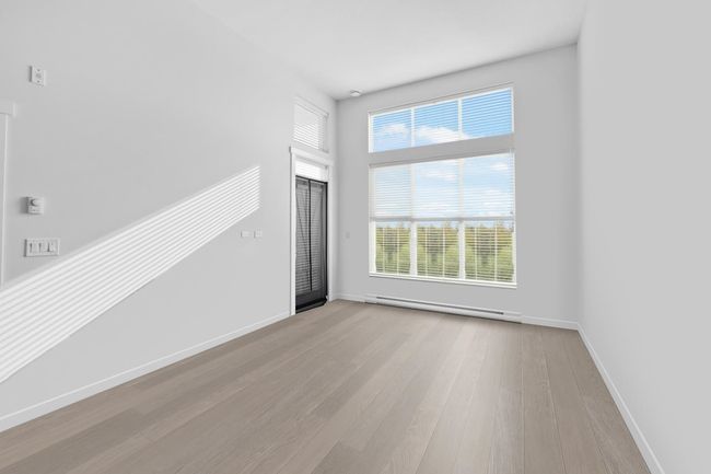 Interior space with baseboards, baseboard heating, and wood finished floors | Image 6
