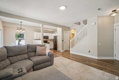 Living room featuring wood-type flooring and an inviting chandelier | Image 3