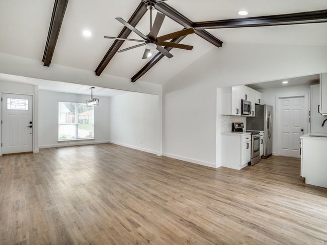 Unfurnished living room with beamed ceiling, baseboards, light wood finished floors, a sink, and recessed lighting | Image 4