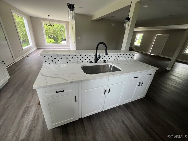 Kitchen featuring a sink, light stone countertops, open floor plan, and dark wood finished floors | Image 11