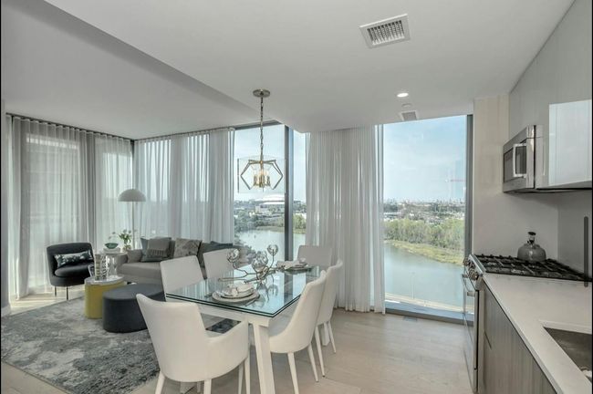 Dining area featuring a chandelier, a water view, floor to ceiling windows, and light wood-type flooring | Image 8