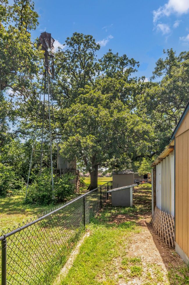 Fenced backyard with a storage shed | Image 31