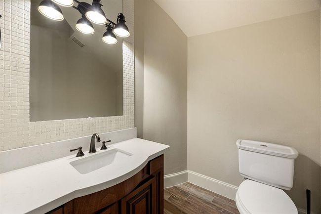 Half bathroom located under the stairs off the living room. | Image 26