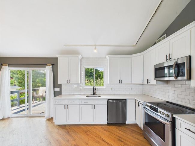 Kitchen featuring appliances with stainless steel finishes, light wood-style flooring, and healthy amount of natural light | Image 7