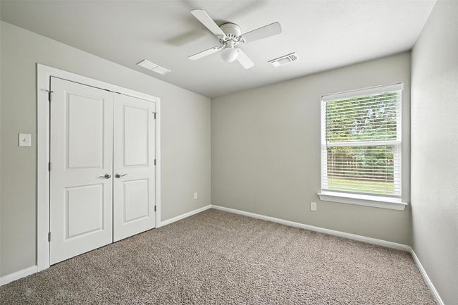 Unfurnished bedroom featuring carpet, ceiling fan, and a closet | Image 9
