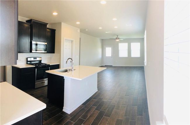 Kitchen featuring stainless steel appliances, a ceiling fan, light countertops, and recessed lighting | Image 4