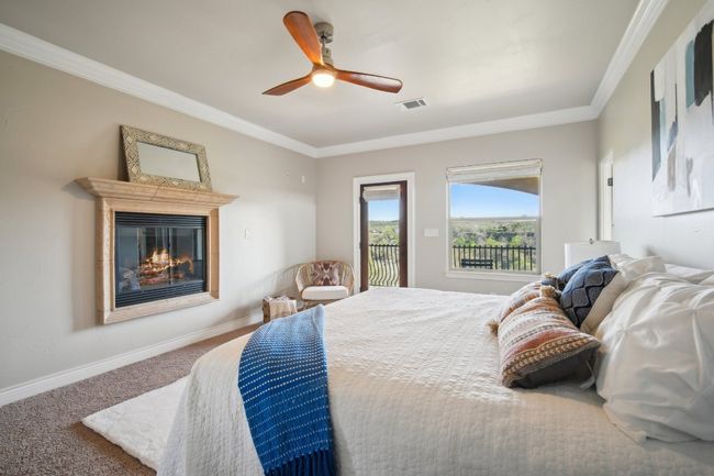 Bedroom featuring baseboards, visible vents, carpet floors, access to exterior, and a glass covered fireplace | Image 19