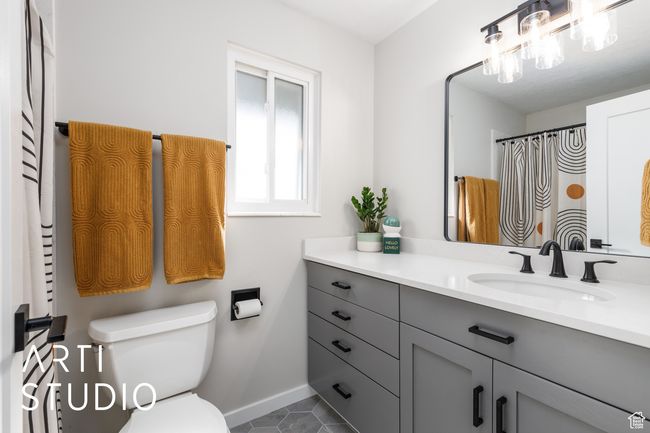 Bathroom with toilet, vanity, tile patterned floors, and baseboards | Image 19