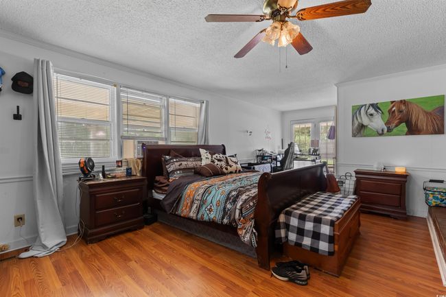 Bedroom with a textured ceiling, light wood-style floors, access to outside, a ceiling fan, and crown molding | Image 22