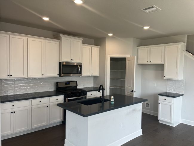 Kitchen with a sink, dark countertops, stainless steel appliances, and visible vents | Image 13