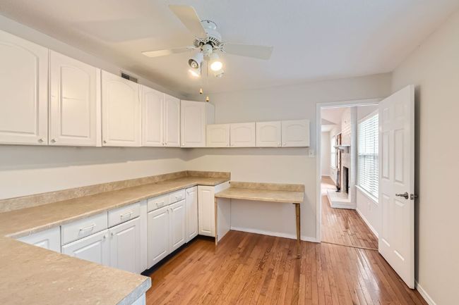 Kitchen featuring visible vents, light wood-style flooring, ceiling fan, and white cabinets | Image 12