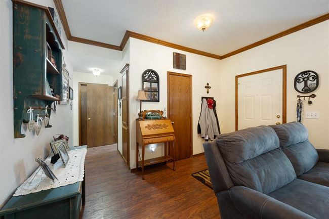 Living room featuring visible vents, ornamental molding, and dark wood-style flooring | Image 21