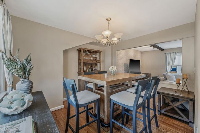 Dining room with dark hardwood / wood-style floors and an inviting chandelier | Image 6