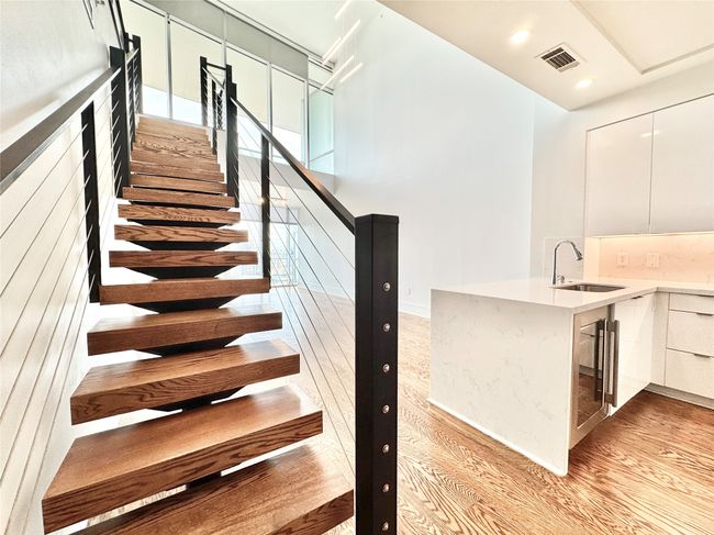 Staircase with wood finished floors, beverage cooler, recessed lighting, and baseboards | Image 7