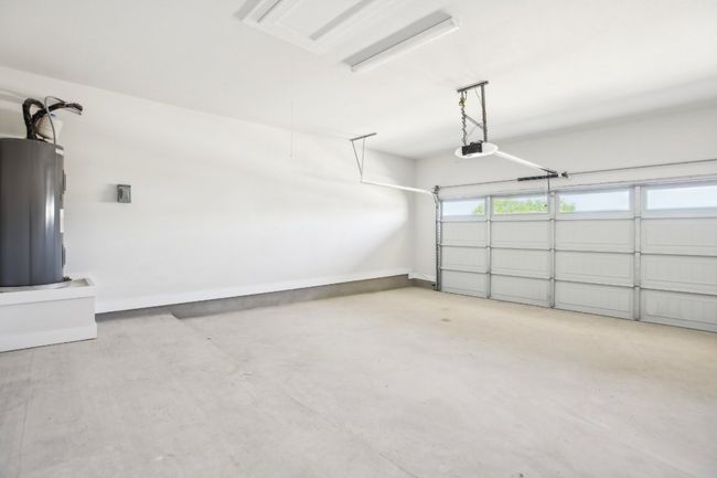 Garage featuring a garage door opener, baseboards, and water heater | Image 29