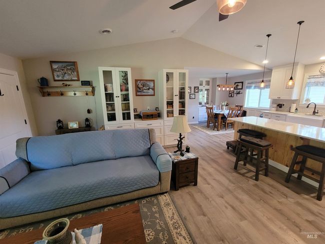 Living room featuring vaulted ceiling, light wood finished floors, and a ceiling fan | Image 14