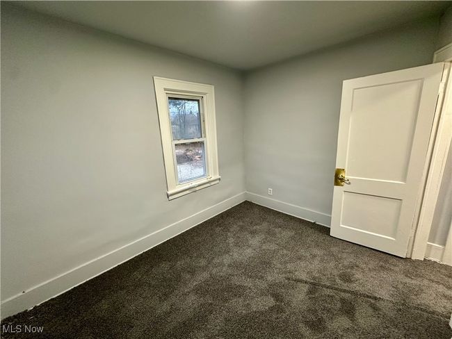 Empty room with dark colored carpet and baseboards | Image 5