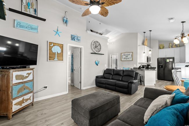 Living area featuring baseboards, a ceiling fan, wood finished floors, and a healthy amount of sunlight | Image 18