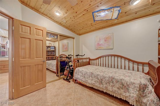 Tiled bedroom with vaulted ceiling, wooden ceiling, a closet, and recessed lighting | Image 54