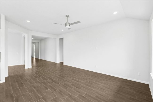 Unfurnished room featuring a ceiling fan, recessed lighting, dark wood-style flooring, and baseboards | Image 11
