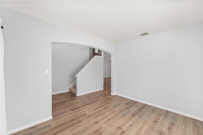 Spare room with new laminate flooring, arched walkways, and stairs | Image 10
