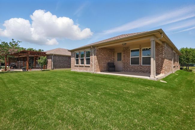 Rear view of house featuring a lawn, brick siding and a covered patio | Image 25