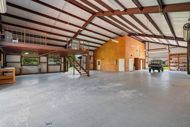 Interior view of workshop showing garage apartment in the rear and upper level storage. | Image 33