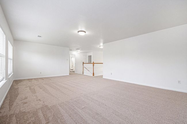 this spacious, game room loft area features neutral tones and ample lighting, with open railing overlooking the floor below, providing a versatile space for many uses. | Image 13