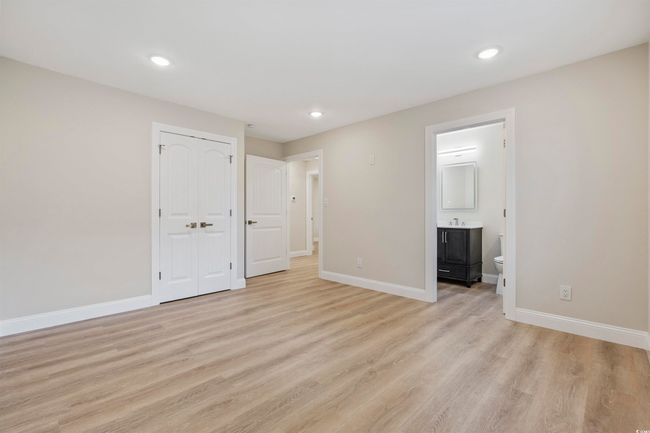 Unfurnished bedroom featuring light wood-style flooring, baseboards, recessed lighting, a closet, and ensuite bathroom | Image 15