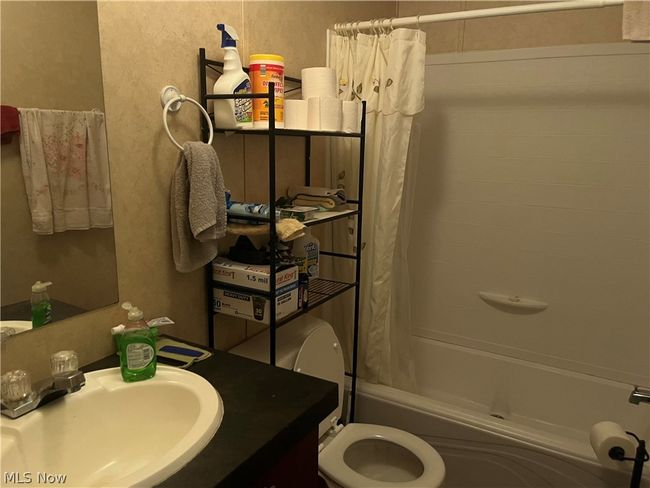 Full bathroom with vanity, toilet, and shower / bath combo with shower curtain | Image 6