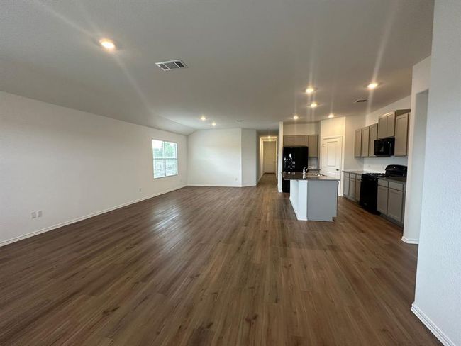 Kitchen with black appliances, open floor plan, gray cabinets, dark wood-style floors, and a sink | Image 19