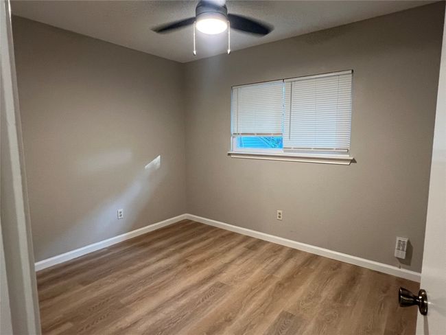 Spare room featuring wood finished floors, baseboards, and ceiling fan | Image 15