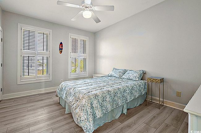 Bedroom with a ceiling fan, baseboards, and wood finished floors | Image 15