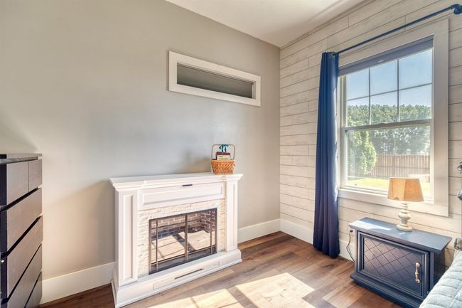 Living area with plenty of natural light, wood finished floors, and wood walls | Image 18