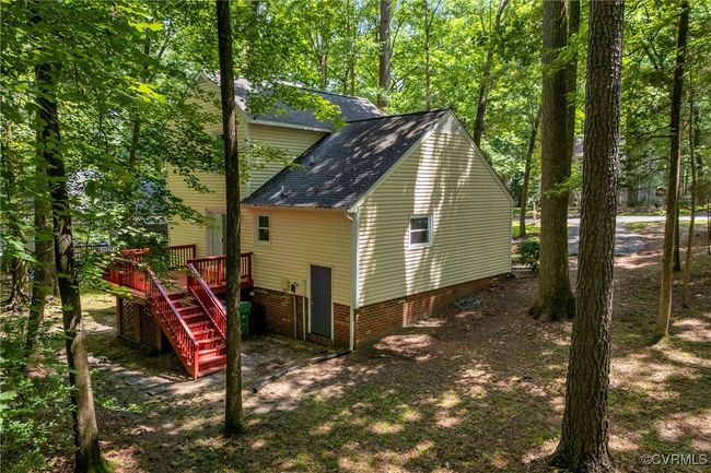 View of property exterior featuring a shingled roof, stairs, and deck | Image 30