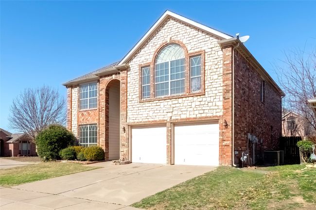 Traditional home with concrete driveway, brick siding, an attached garage, and cooling unit | Image 38