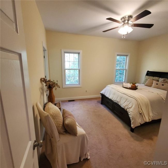 Bedroom with carpet flooring, visible vents, baseboards, and ceiling fan | Image 25