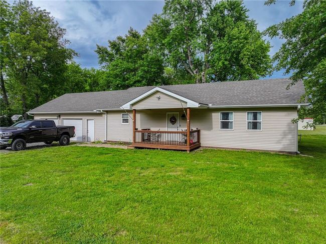 Ranch-style house with an attached garage, a front yard, a wooden deck, and roof with shingles | Image 45
