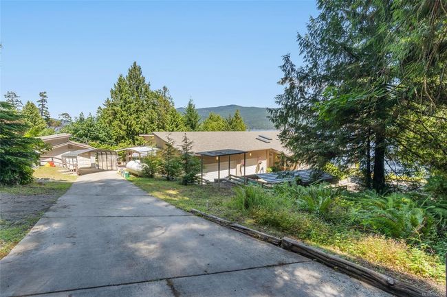 View of property hidden behind natural elements with concrete driveway and a mountain view | Image 77