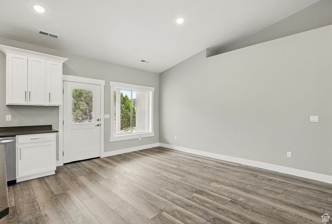 Unfurnished living room featuring lofted ceiling, wood finished floors, baseboards, and recessed lighting | Image 16