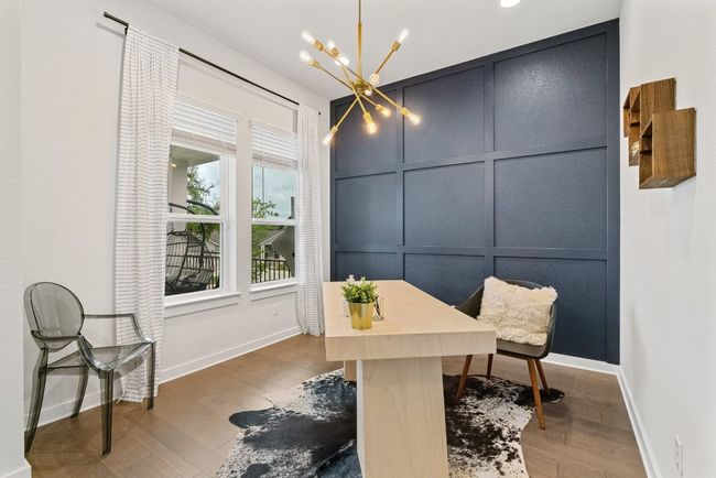 Office area featuring a chandelier, wood finished floors, and a decorative wall | Image 6
