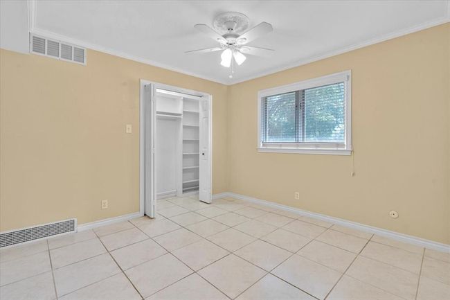 Unfurnished bedroom featuring ornamental molding, light tile patterned floors, and ceiling fan | Image 21