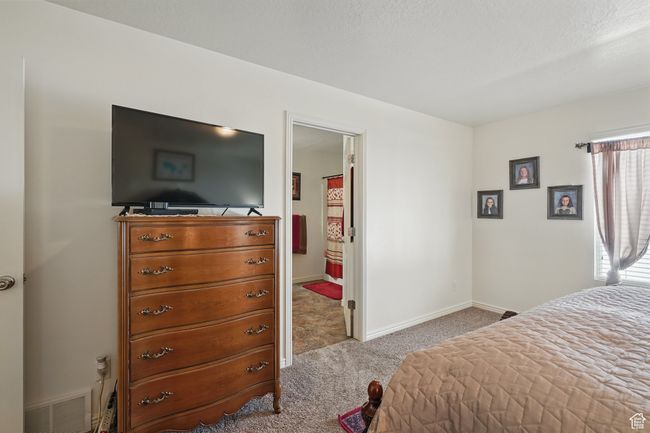 Carpeted bedroom featuring visible vents and baseboards | Image 22
