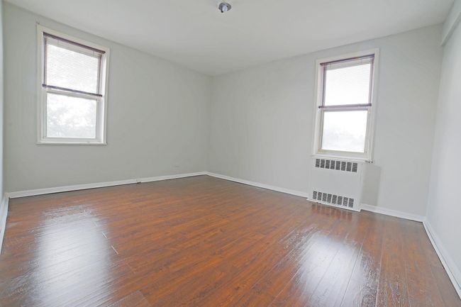 Unfurnished room with radiator and dark wood-style flooring | Image 4