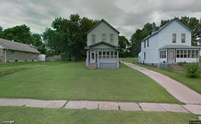 View of front of house with a sunroom and a front yard | Image 1