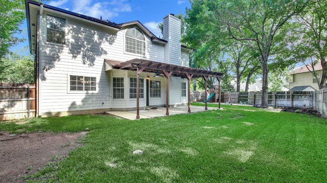 Rear view of house with a pergola, a chimney, and a patio | Image 21